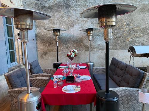 圣皮埃尔－勒穆捷LE CHARME DE ST PIERRE的一张桌子,上面有红桌布和一些灯