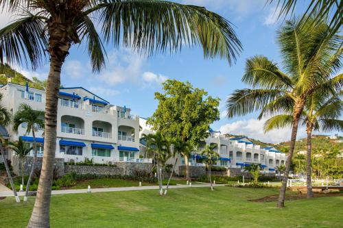 RaphuneLimetree Beach Resort by Club Wyndham的一座大型白色建筑,前方有棕榈树