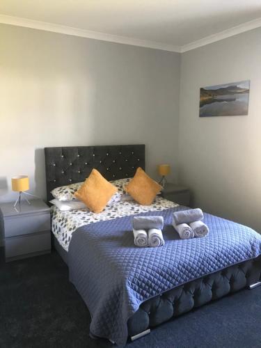 波特里4 York Drive, Portree , Isle Of Skye的一间卧室配有一张带蓝色床单和橙色枕头的床。