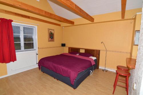 ÖrsundsbroHustugu Gård的一间卧室设有一张床、一个窗口和一把椅子