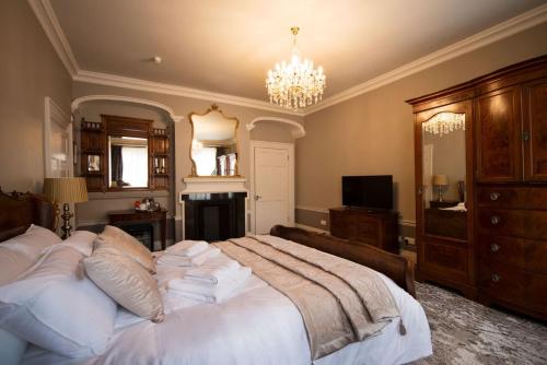 奇切斯特East Walls Hotel的卧室配有一张带吊灯的大型白色床。