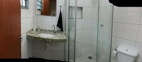 巴乌鲁Casa - Chácara Bella Arraes的一间带水槽和玻璃淋浴的浴室