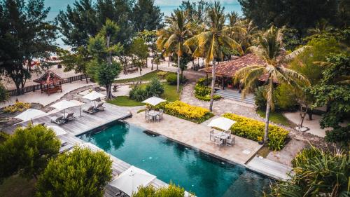 吉利特拉旺安德萨度尼亚贝达度假酒店的享有带遮阳伞和棕榈树的泳池的空中景致