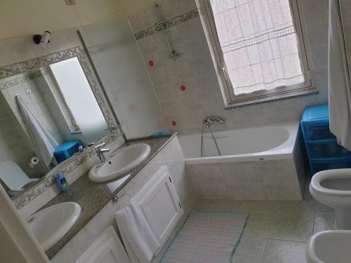 奥里斯塔诺Casa Marcy的一间带两个盥洗盆、浴缸和卫生间的浴室