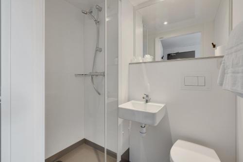 布鲁瓦initial by balladins Blois的白色的浴室设有水槽和淋浴。