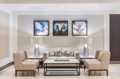 吉达Qamar Hotel Jeddah的客厅配有沙发和两把椅子