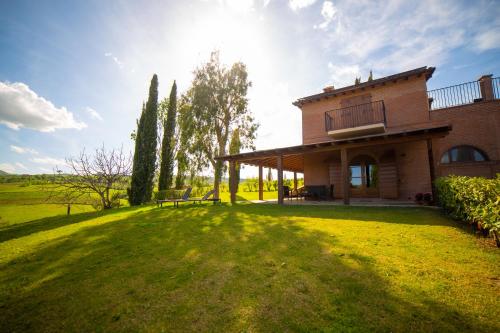 蒙特普齐亚诺Terra Antica - Resort, Winery & SPA的草地上的房子,太阳在后面