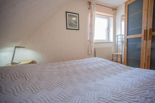 达默An der Aue 15 Wohnung Ley的卧室配有一张大白色床和窗户