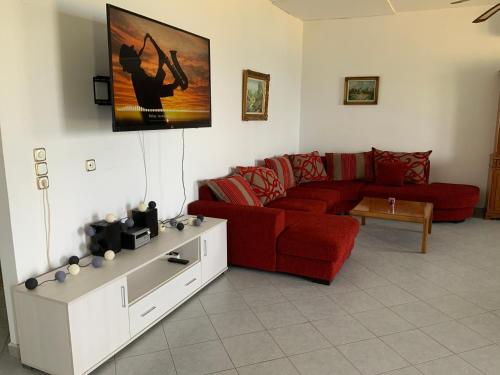 库卡里Xenia Apartment的客厅配有红色的沙发和桌子