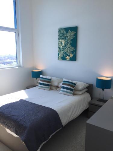 贝德福德Sky View Apartment with Terrace的一间卧室配有一张大床和两盏蓝色灯