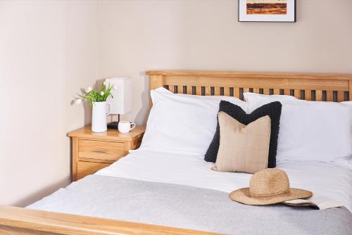 埃克塞特Swallows End - Apartment with hot tub, sauna and pool (Dartmoor)的一间卧室,配有一张床,上面有帽子