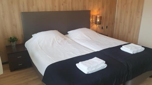 MeijelGrand Café Goejje voorheen Oranje Hotel的一间卧室配有一张床,上面有两条毛巾