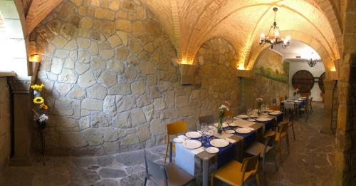 圣塞瓦斯蒂安爱美塔各娜膳食公寓的一间带桌椅和石墙的用餐室