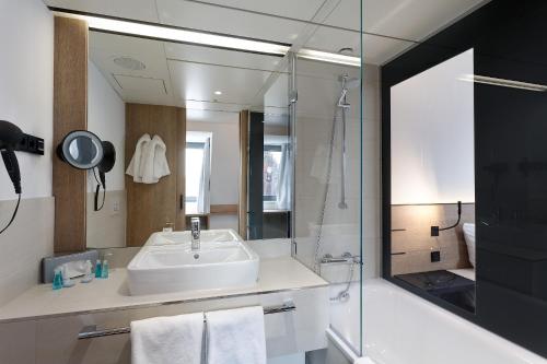 纽伦堡纽伦堡索拉特萨克斯酒店的一间带水槽、淋浴和镜子的浴室