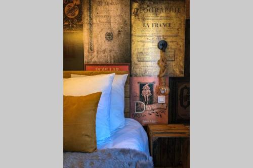 科尔马Un petit Vintage à Colmar的一间卧室配有床和一堵带书籍的墙壁
