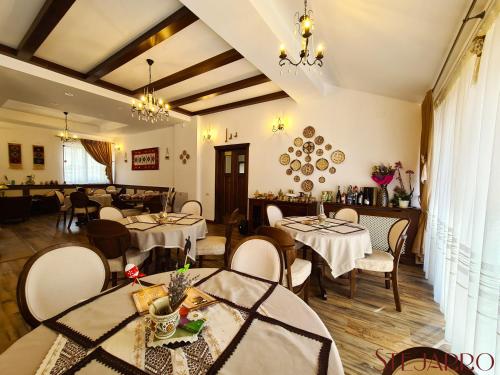 StejaruStejarro Conac Moldovenesc的一间在房间内配有桌椅的餐厅
