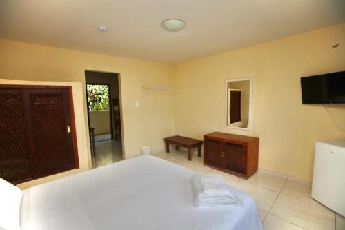 伊利亚贝拉Colonial Hotel的卧室配有白色的床和电视。