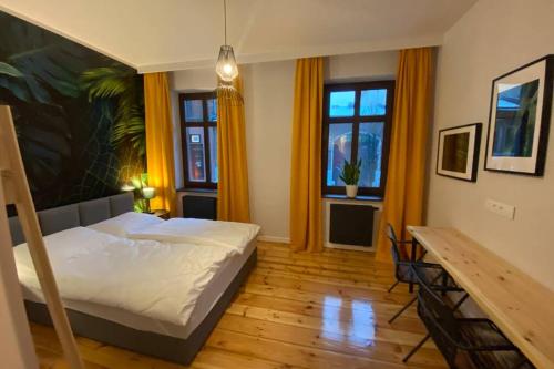大波兰地区奥斯特鲁夫Stylowy apartament tuż przy Rynku的卧室配有床、桌子和窗户。