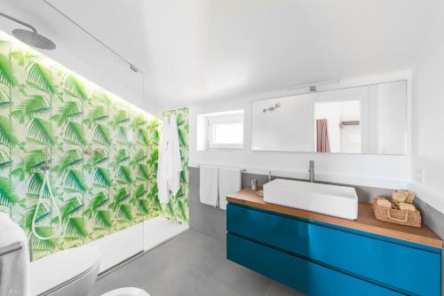 维克艾库塞Enfasi Holiday Home的浴室设有蓝色水槽和绿叶壁纸