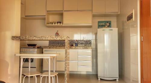 圣卡洛斯BALI - PAZ & CONFORTO COM WIFI e VAGA,Máx4 pessoas的厨房配有冰箱和桌子