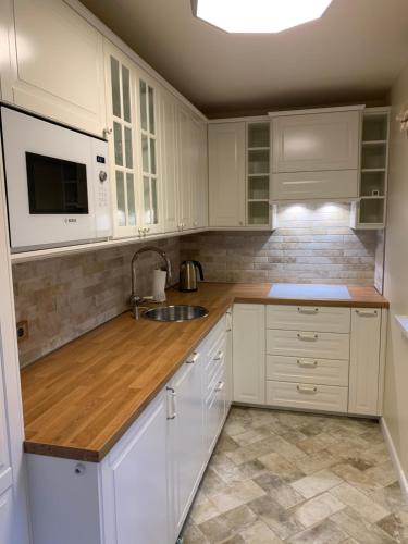 帕兰加Vaineikio 8的厨房配有白色橱柜、水槽和微波炉