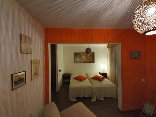 OlivoneCuore Alpino的一间卧室拥有橙色的墙壁,床上配有橙色枕头