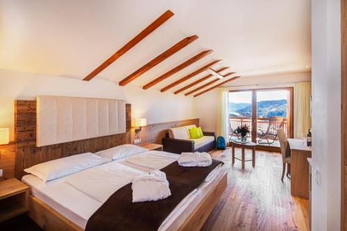菲耶Hotel Gasthof Kircher的一间卧室配有一张床、一张书桌和一个窗户。