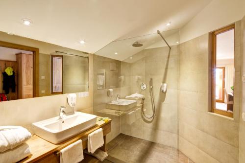 菲耶Hotel Gasthof Kircher的一间带水槽和淋浴的浴室