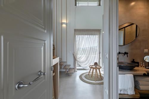 卡利斯托斯Evais Boutique Houses & Luxury Suites的走廊设有带水槽和浴缸的浴室
