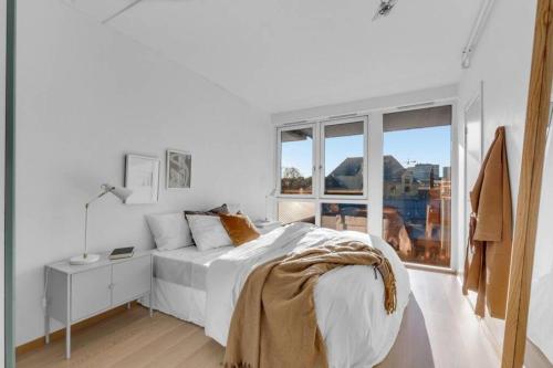 奥斯陆Awardwinning penthouse, Oslo city / Grünerløkka的白色的卧室设有床和窗户