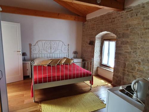 布耶Casa dei Boscarini的一间卧室配有一张带红色毯子的床
