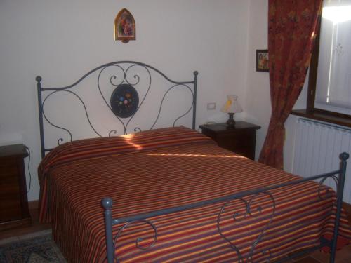佩尔戈拉Agriturismo Lo Sgorzolo的一间卧室配有带条纹被子的床