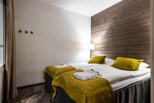 鲁卡RukaValley Unique46 Ski In - Ski Out的酒店客房带两张带黄床单的床