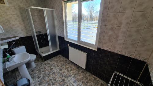 梅尔诺Pensjonat Jan Pokoje nad samym morzem的一间带水槽和卫生间的浴室以及窗户。