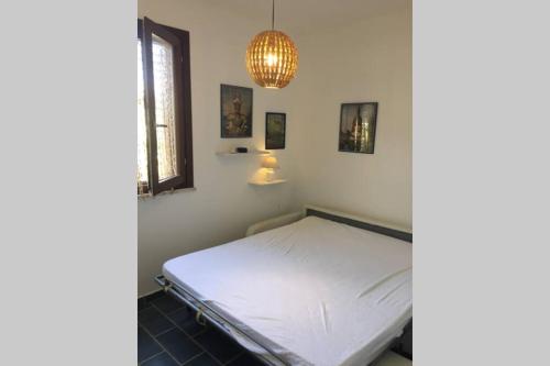 法维尼亚纳Vacanze isolane的卧室配有白色的床和吊灯。