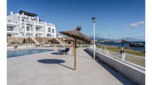 马拉加Casares del Mar Luxury Apartment的一个带游泳池和遮阳伞的度假胜地