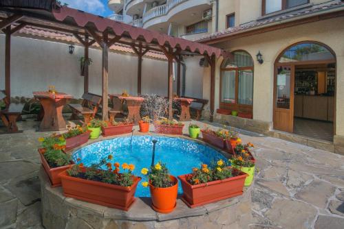 希典Хотел Бриз的庭院设有种有鲜花和植物的游泳池
