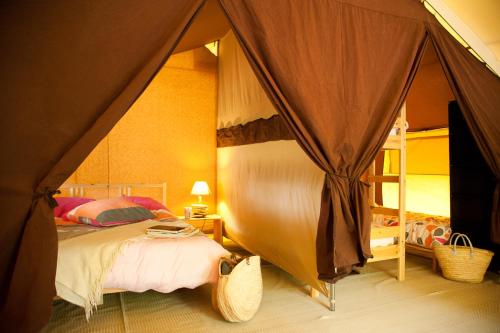 波讷地区圣朱利安Tente Lodge La Téouleyre的帐篷内一间卧室,配有一张床