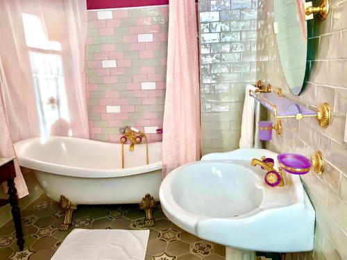 Cissac-MédocChateau Gunes (Guges)的粉红色的浴室设有浴缸和水槽