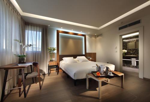 格拉纳达雷格赫达斯阿巴德斯酒店的酒店客房配有一张床铺和一张桌子。