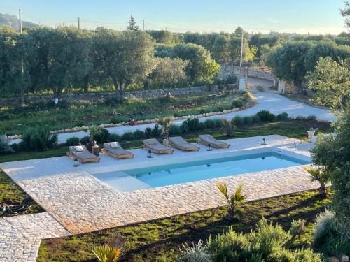 奥斯图尼Relais Grottone的享有带躺椅的花园游泳池的顶部景致
