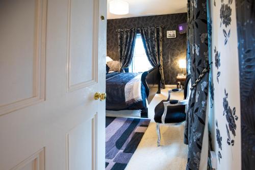 MilltownBruckless Rest - Fine Country Living的走廊上设有一间卧室,配有一张床和椅子