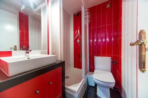 马德里CHUECA Apartamentos的红色的浴室设有白色水槽和卫生间