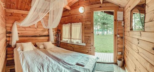 NurmePruuli Puhkeküla的小木屋内一间卧室,配有一张床