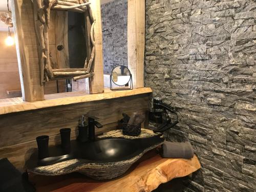 AfaChambres du Gozzi的浴室设有黑色水槽和石墙