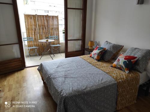 马赛Appartement vacances Marseille的一间卧室配有一张床,阳台配有桌子