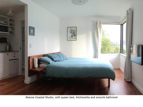 阿卡罗阿Akaroa Coastal Studio的一间卧室设有一张床和一个窗口