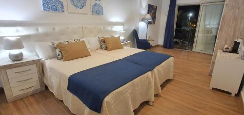 阿利坎特Sandra Rooms的一间卧室配有一张带蓝色毯子的大床