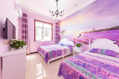 秦皇岛北戴河海之恋假日公寓的一间卧室设有两张床和紫色墙壁