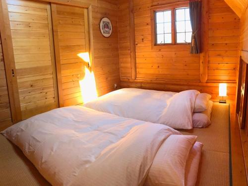 KannamiA Private Log House with Mt Fuji View & Piano - "Thangtong House Japan"的木制客房内的一间卧室配有两张床